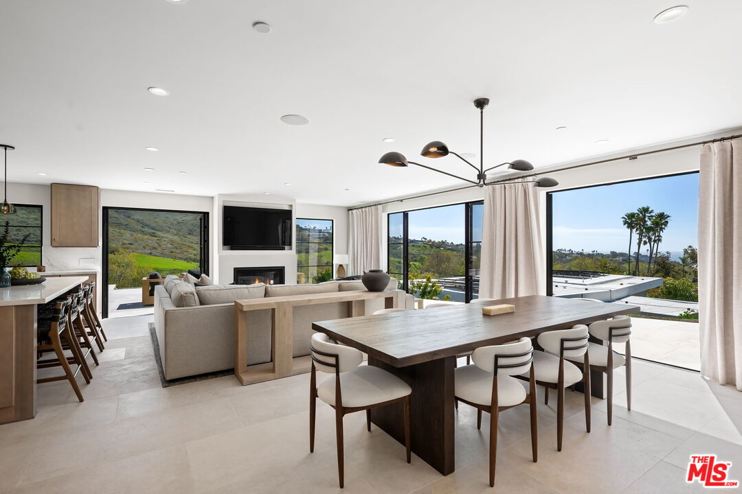 6326 Trancas Canyon Road Malibu, CA 90265 - Photo 6 of 53 a dining room with wooden floor a chandelier a wooden table and chairs