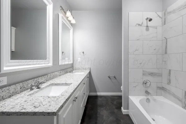 a bathroom with a granite countertop sink a toilet and bathtub