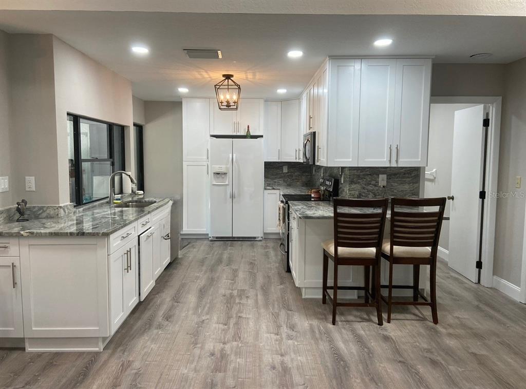 35 Pinewinds Boulevard Oldsmar, FL 34677 - Photo 12 of 36 a large kitchen with a table and chairs in it