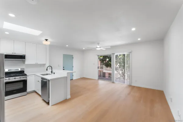 a kitchen with stainless steel appliances granite countertop a stove top oven a sink and a refrigerator