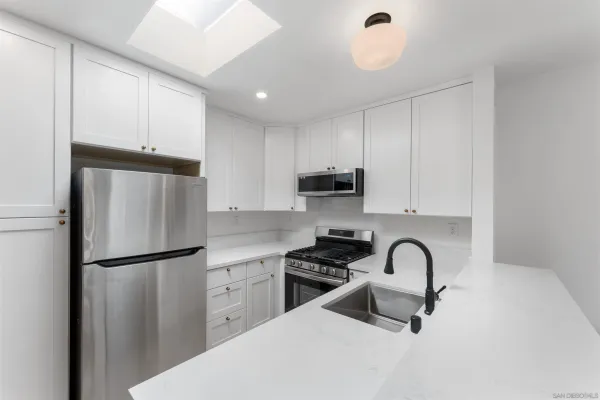 a kitchen with stainless steel appliances a refrigerator sink and cabinets