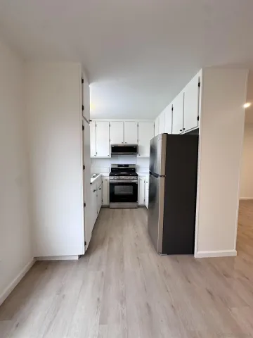 a kitchen with granite countertop a refrigerator and a stove