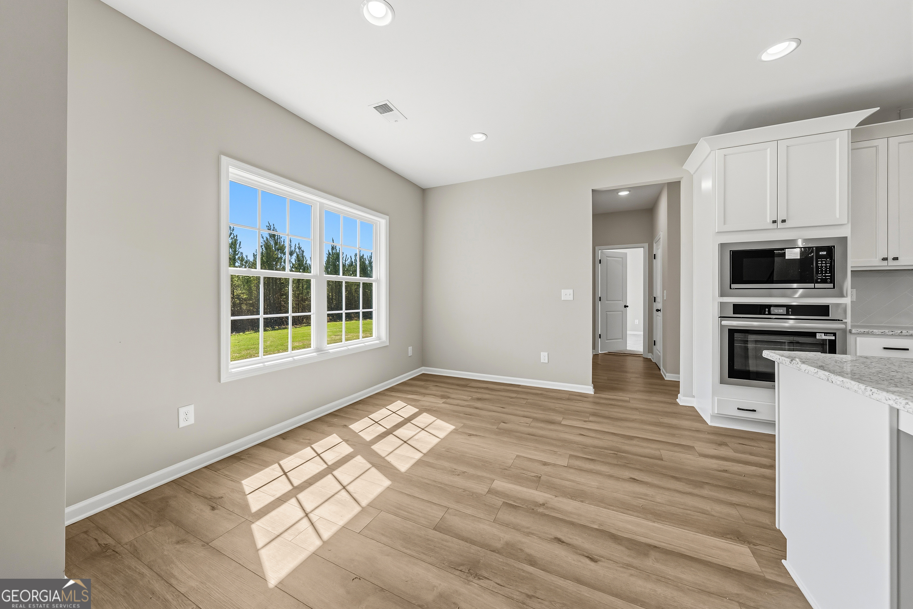 98 Hawkeye Trail, Unit 84 Fortson, GA 31808 - Photo 11 of 42 a view of a kitchen with wooden floor and a sink