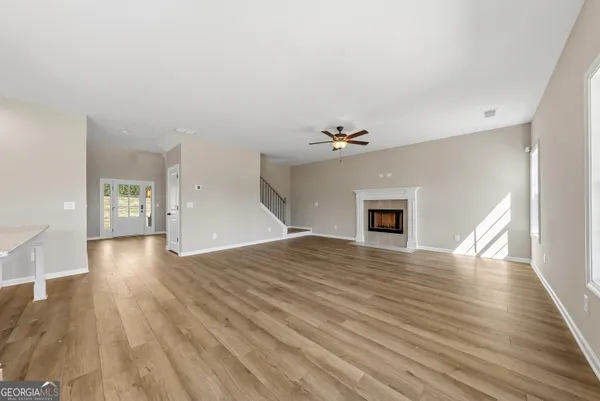 a view of empty room with wooden floor and fireplace