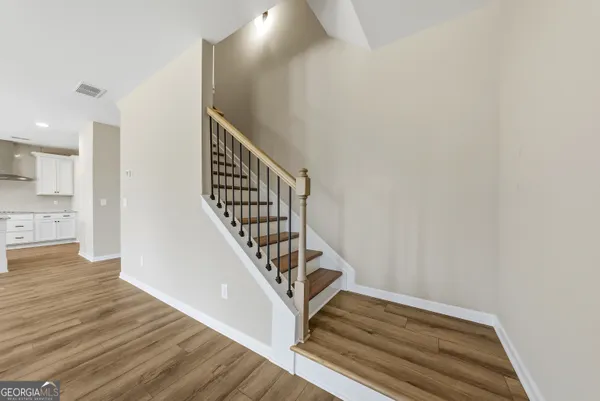 a view of entryway and hall with wooden floor