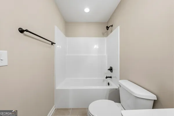 a white toilet and tub sitting next to a bathroom sink