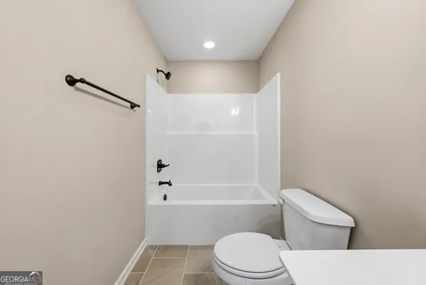 a white toilet sitting next to a bath tub