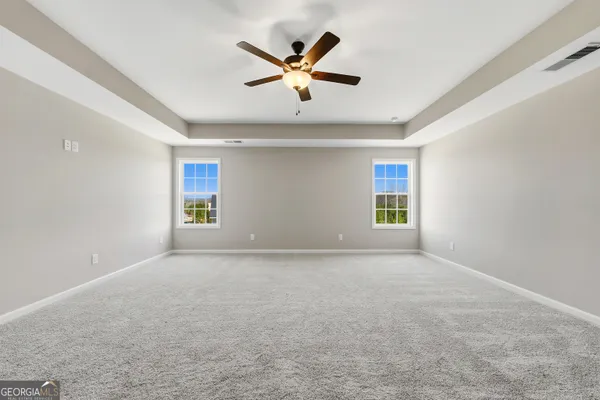 a view of an empty room with a ceiling fan