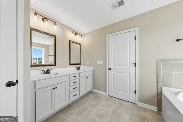 a spacious bathroom with a double vanity sink mirror and