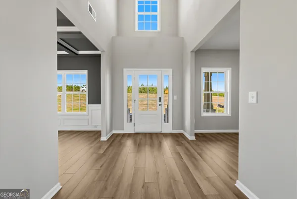 an empty room with wooden floor and windows