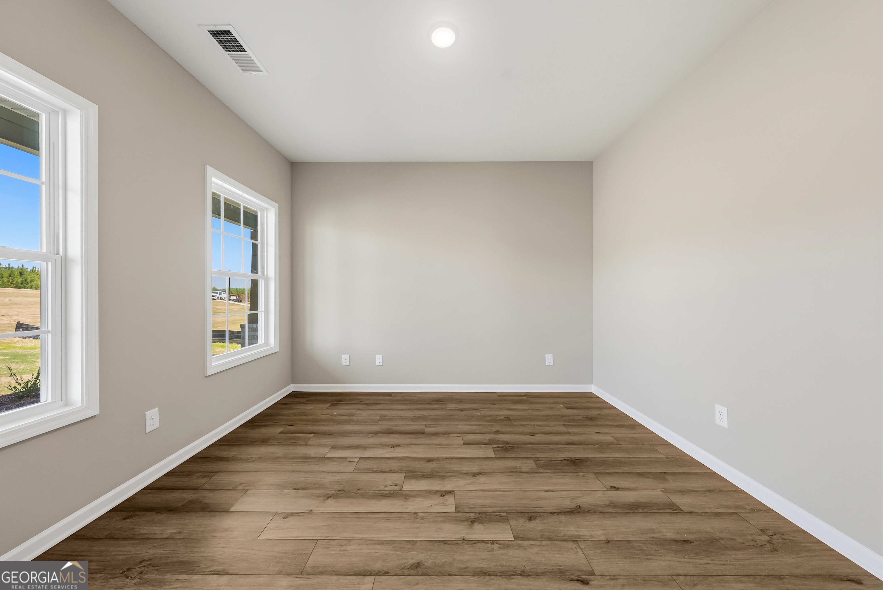 98 Hawkeye Trail, Unit 84 Fortson, GA 31808 - Photo 5 of 42 a view of an empty room with wooden floor and a window