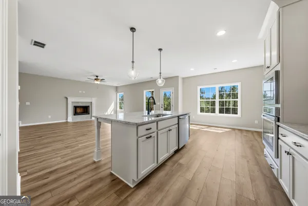 a kitchen with stainless steel appliances granite countertop a stove and a wooden floors