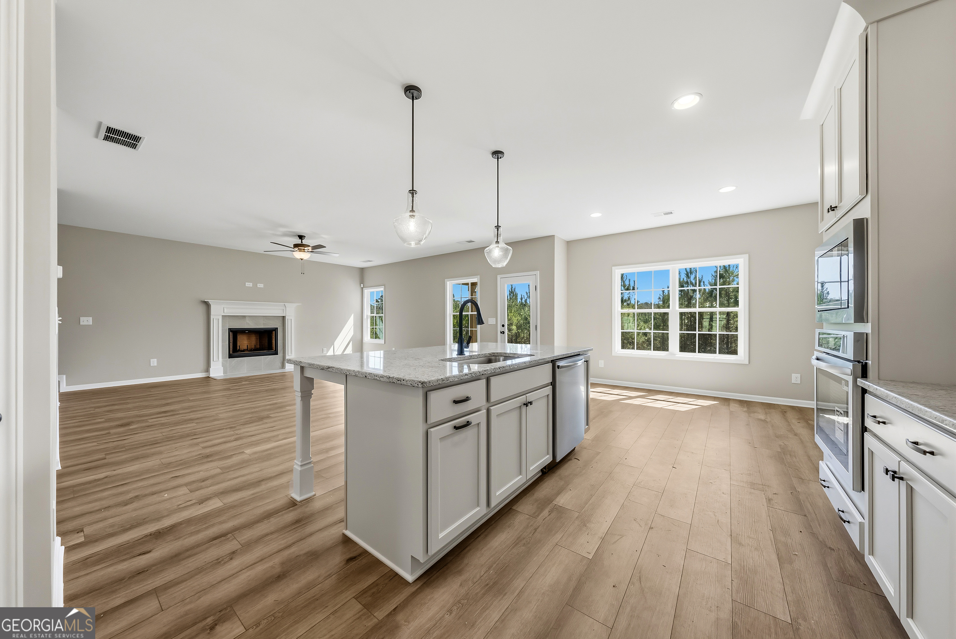 98 Hawkeye Trail, Unit 84 Fortson, GA 31808 - Photo 8 of 42 a kitchen with stainless steel appliances granite countertop a stove and a wooden floors