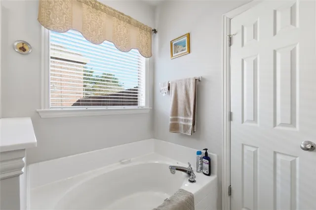 a bathroom with a bathtub and a window