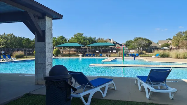 a view of a chairs and table in the patio with a swimming pool