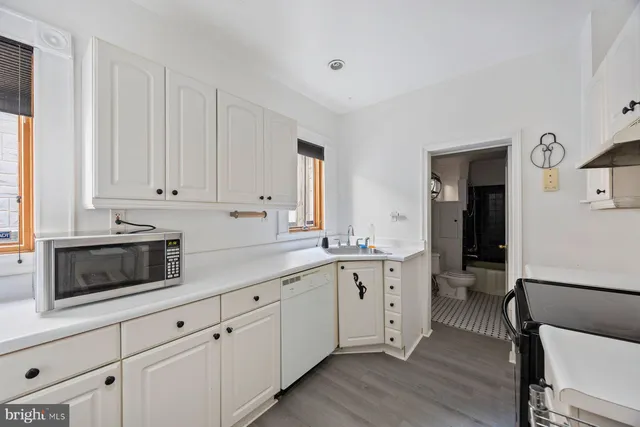 a kitchen with granite countertop white cabinets and white appliances