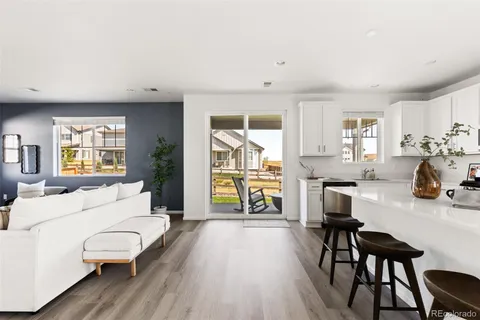 a living room with furniture a wooden floor and a large window