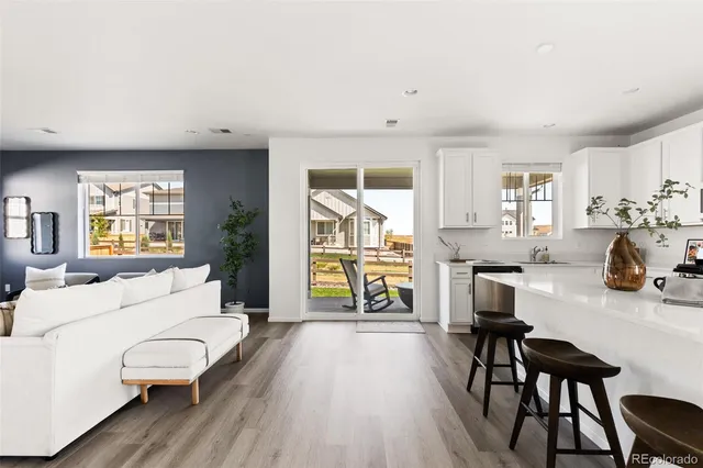 a living room with furniture a wooden floor and a large window