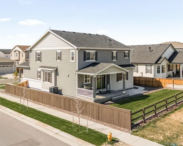 a front view of a house with a yard and deck