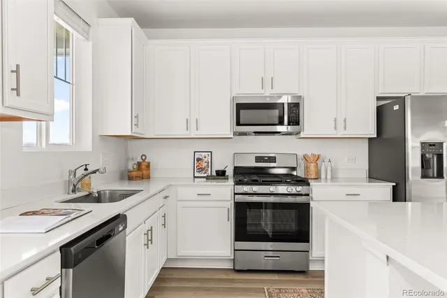 a kitchen with cabinets stainless steel appliances and sink