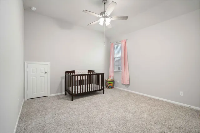 an empty room with windows and ceiling fan