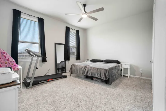 a spacious bedroom with a bed and a chandelier