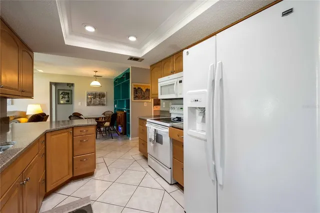 a kitchen with stainless steel appliances granite countertop a refrigerator and a stove top oven