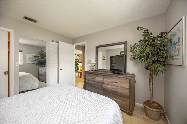 a bedroom with a bed and a potted plant