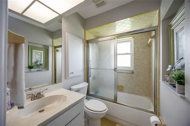 a bathroom with a sink a mirror a toilet and shower