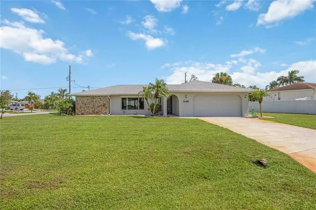 a front view of house with yard and garage