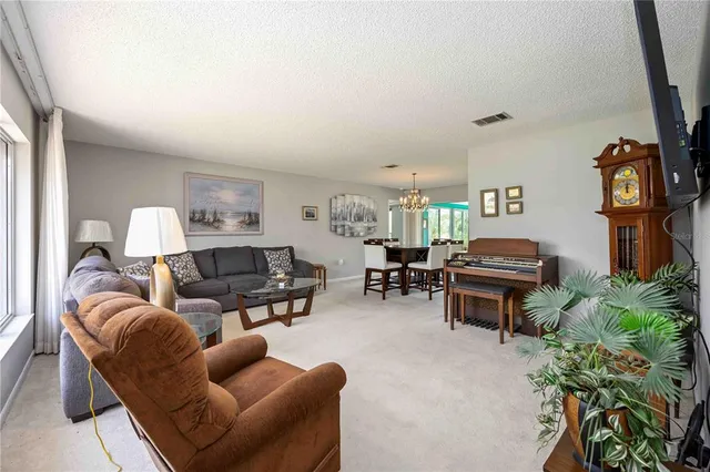 a living room with furniture a piano and a bookshelf