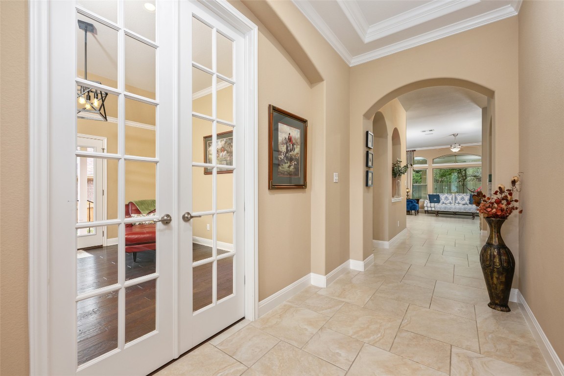 399 Whispering Wind Way Austin, TX 78737 - Photo 11 of 40 Corridor with crown molding, arched walkways, and french doors