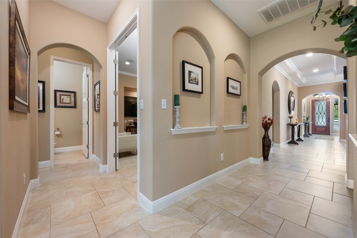 399 Whispering Wind Way Austin, TX 78737 - Photo 23 of 40 Hall featuring crown molding, recessed lighting, and arched walkways
