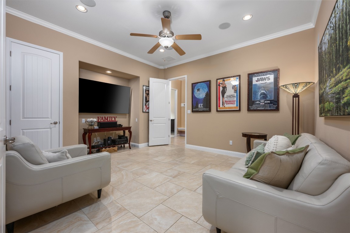 399 Whispering Wind Way Austin, TX 78737 - Photo 24 of 40 Living room featuring a ceiling fan, crown molding, and recessed lighting