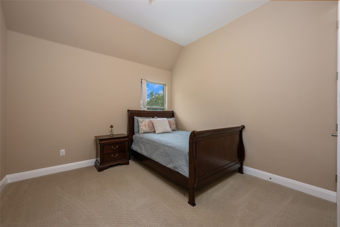 399 Whispering Wind Way Austin, TX 78737 - Photo 28 of 40 Bedroom with light colored carpet and lofted ceiling
