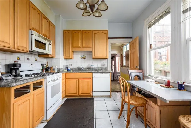 a kitchen with stainless steel appliances granite countertop a sink a stove and a refrigerator