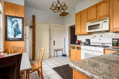 a kitchen with stainless steel appliances granite countertop a stove top oven a sink dishwasher and white cabinets with wooden floor