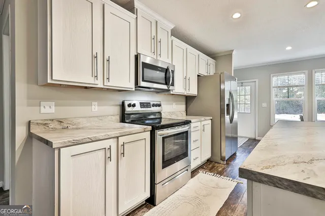 a kitchen with stainless steel appliances granite countertop a stove a sink and a microwave