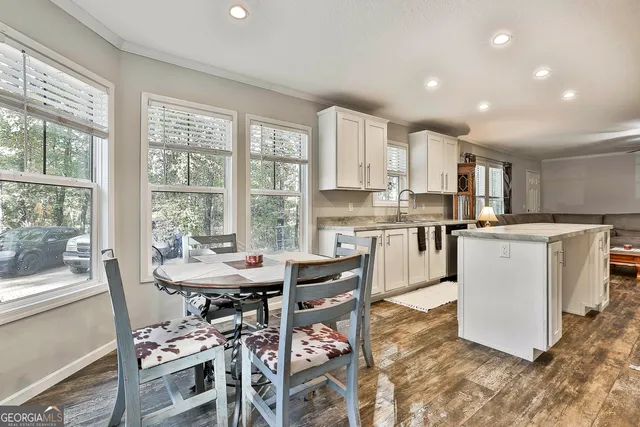 a kitchen with a table chairs microwave and cabinets