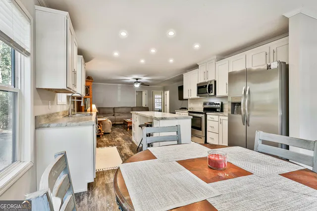 a living room with stainless steel appliances furniture or kitchen view and a kitchen view