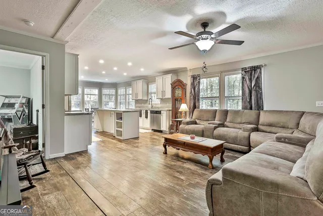 a living room with furniture kitchen view and a chandelier