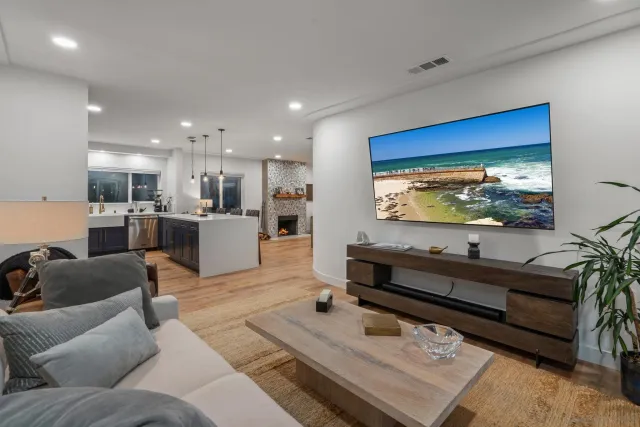 a bedroom with a large bed and a flat tv screen on dresser