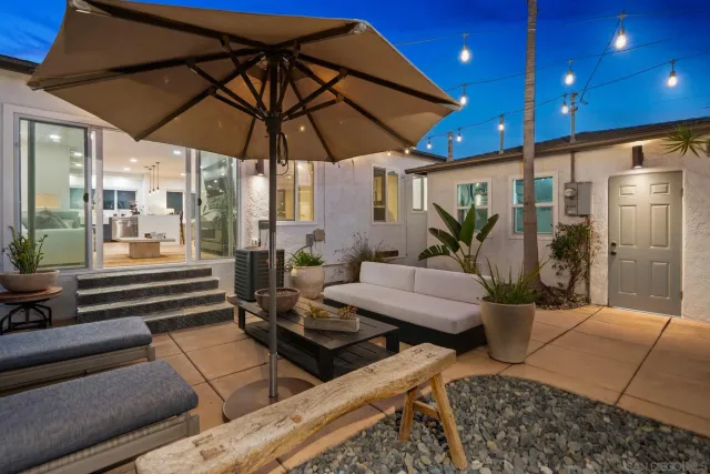 a view of patio with a table and chairs under an umbrella