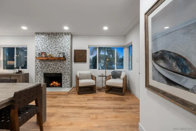 a kitchen with stainless steel appliances kitchen island granite countertop a dining table chairs and white cabinets