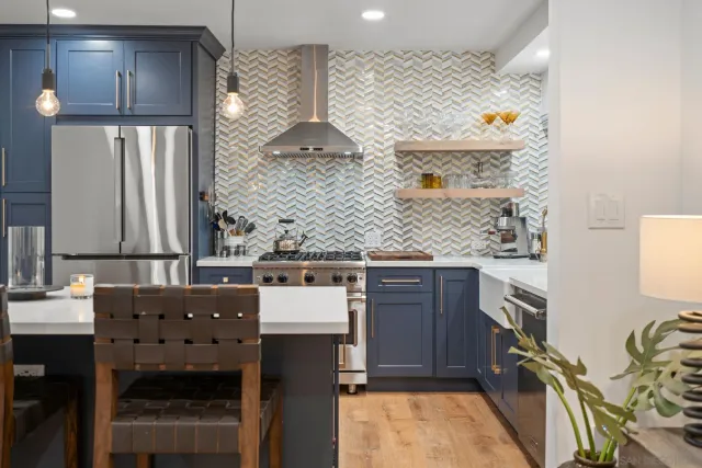 a kitchen with stainless steel appliances kitchen island a table chairs and a refrigerator