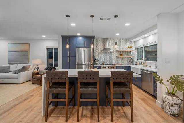 a large kitchen with stainless steel appliances a sink and a refrigerator