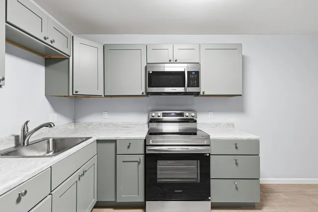 a kitchen with stainless steel appliances a sink a stove a refrigerator and cabinets