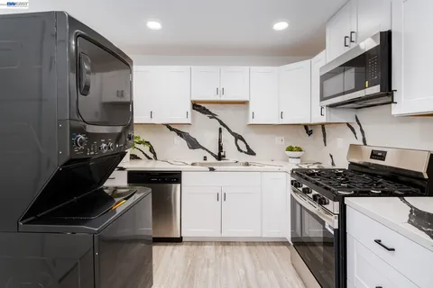 a kitchen with kitchen island a stove sink and cabinets