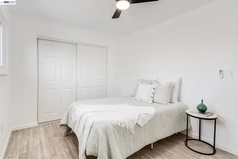 a bedroom with a bed and a potted plant on a dresser