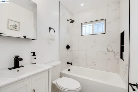 a bathroom with a bathtub shower sink vanity and toilet